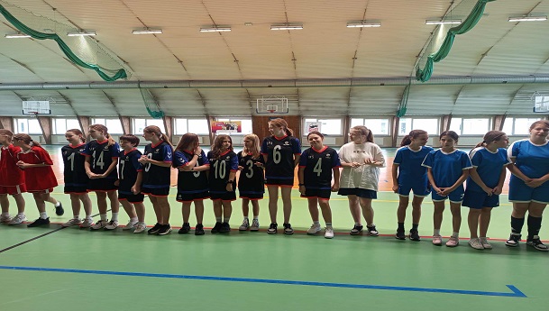Na zdjęciu znajdują się dziewczęta po zakończeniu zawodów sportowych, ustawione w jednym szeregu.