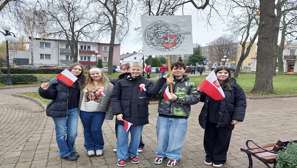 uczniowie pozują na tle popiersia piłsudskiego