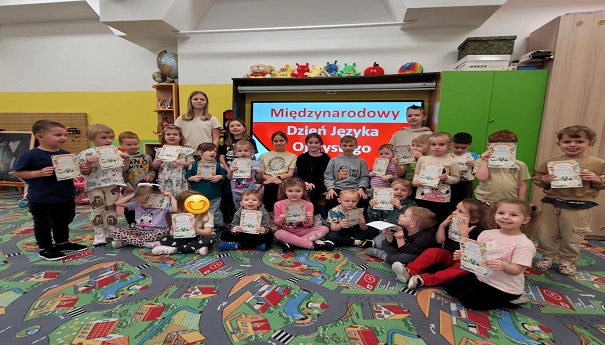 grupa dzieci siedząca przed tablicą