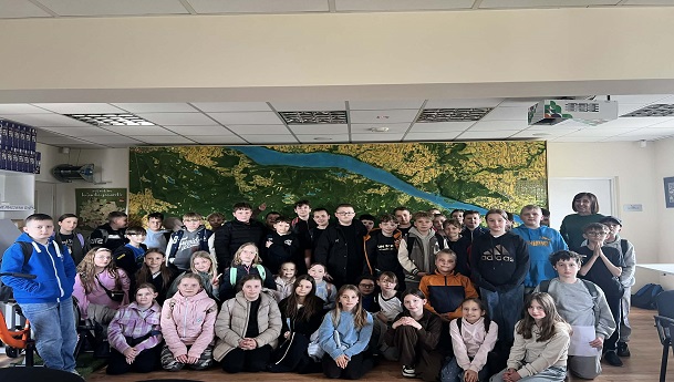 Na zdjęciu są uczniowie, w tle widać mapę Parku Narodowego.